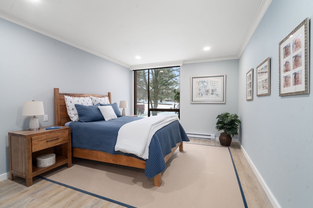 65 Grove Wellesley Ma, Unit 152 Wellesley, MA 02482 - Photo 7 of 16 a spacious bedroom with a bed and a chandelier