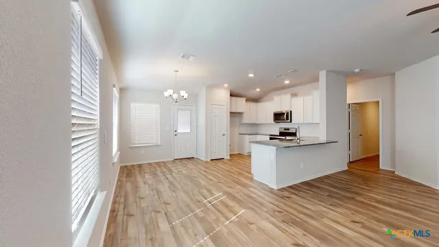 a view of kitchen with kitchen island wooden floor wooden floor and stainless steel appliances