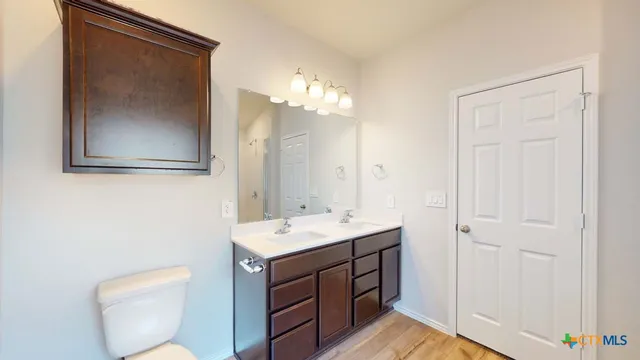 a bathroom with a toilet a sink and mirror
