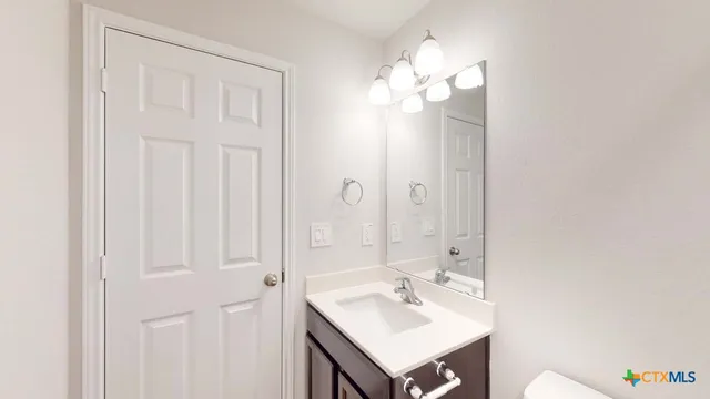 a bathroom with a sink vanity and a mirror