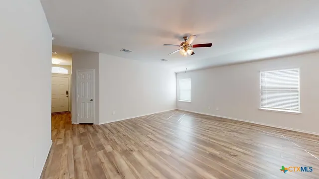 wooden floor in an empty room with a window