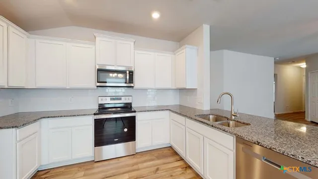 a kitchen with stainless steel appliances granite countertop a sink and a stove