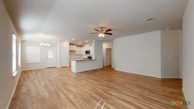a view of a kitchen with kitchen island stainless steel appliances refrigerator sink and cabinets