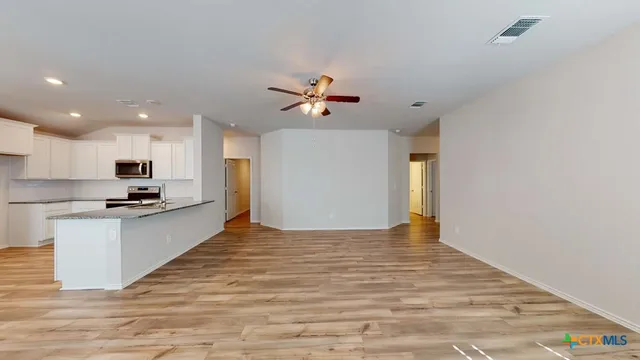 a view of kitchen with sink microwave and stove top oven