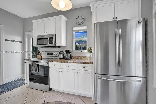 a kitchen with cabinets stainless steel appliances and a counter space