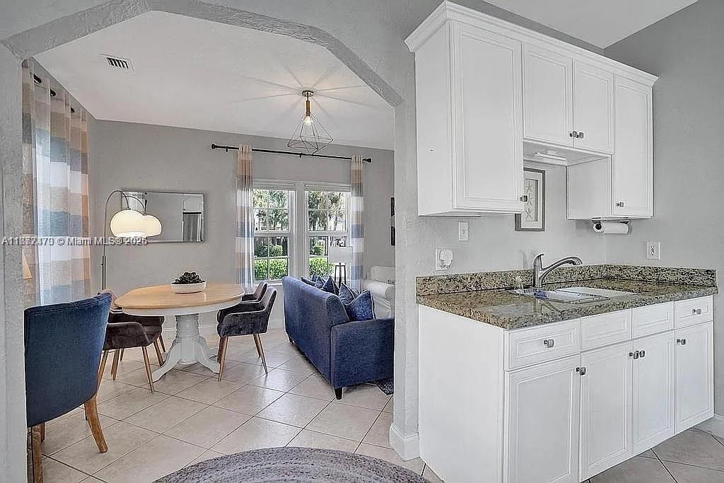 8900 Harding Avenue Surfside, FL 33154 - Photo 13 of 25 a kitchen with a stove a sink a counter space and dining table