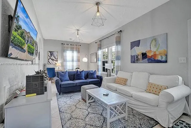 a living room with furniture a ceiling fan and a window