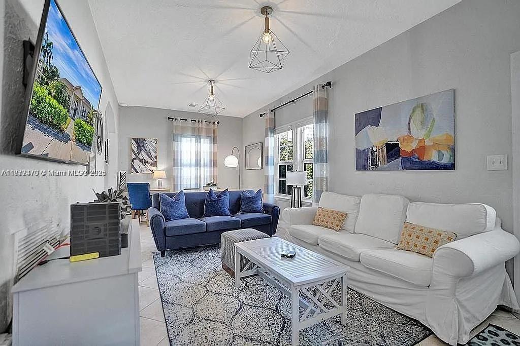 8900 Harding Avenue Surfside, FL 33154 - Photo 8 of 25 a living room with furniture a ceiling fan and a window