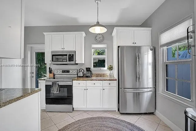 a kitchen with stainless steel appliances granite countertop a refrigerator a stove a sink and a refrigerator