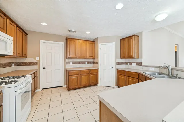 a kitchen with a sink a stove a refrigerator and cabinets