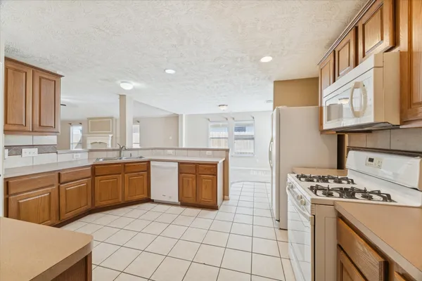 an empty room with windows and chandelier fan