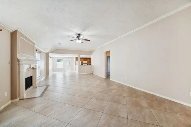a view of a livingroom with a fireplace a chandelier and windows