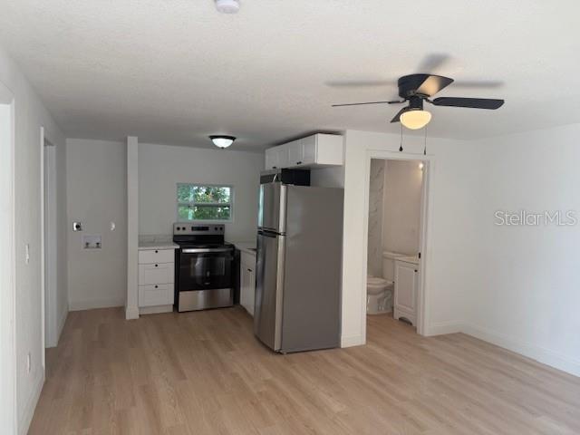 4605 North Hubert Avenue, Unit 19 Tampa, FL 33614 - Photo 3 of 14 a view of a kitchen with a refrigerator a microwave and a ceiling fan