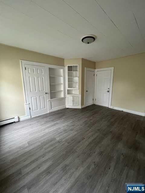 114 Atlantic Street, Unit 1 Hackensack, NJ 07601 - Photo 2 of 8 an empty room with wooden floor and windows