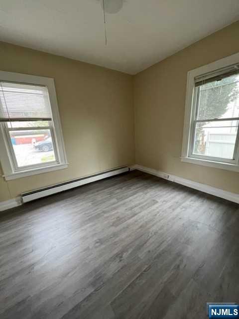 114 Atlantic Street, Unit 1 Hackensack, NJ 07601 - Photo 4 of 8 an empty room with wooden floor and windows