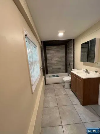 a bathroom with a double vanity sink a mirror and a bathtub