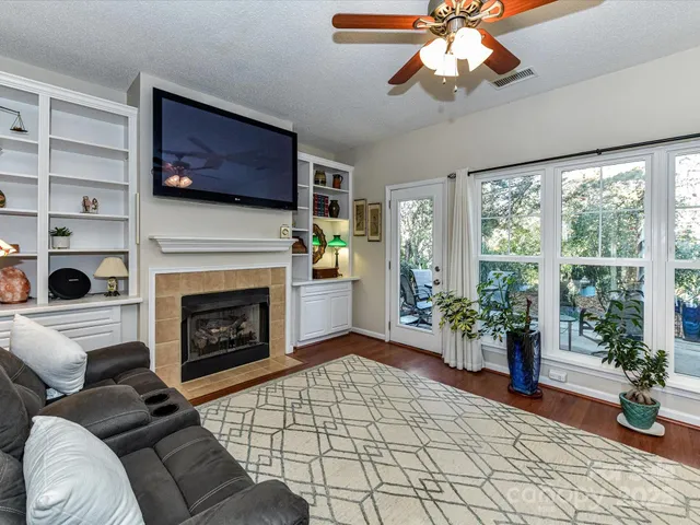 a living room with furniture a flat screen tv and a fireplace