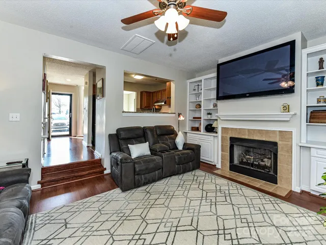 a living room with furniture a flat screen tv and a fireplace
