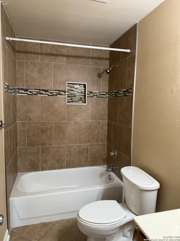 an empty room with window and ceiling fan