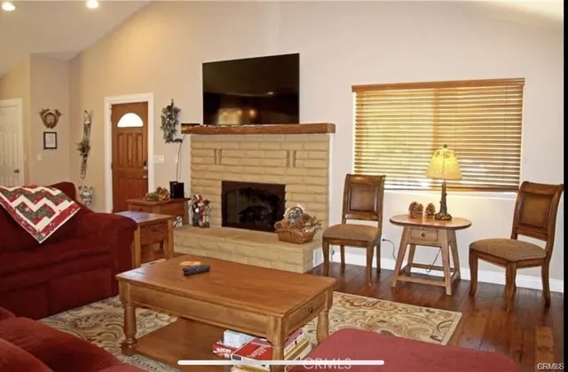 a living room with furniture a flat screen tv and a fireplace