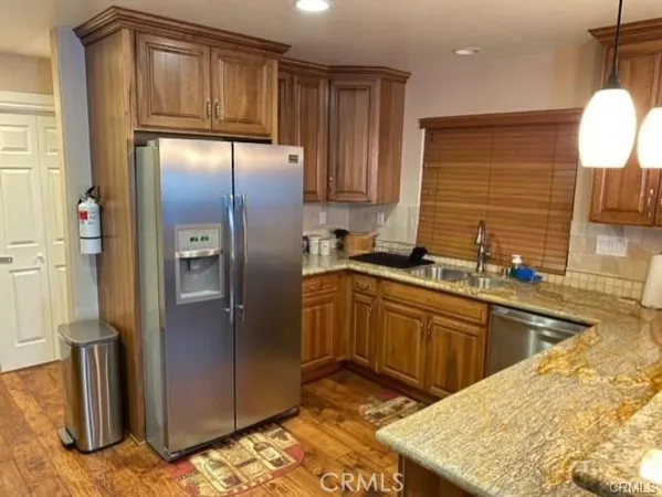 a kitchen with stainless steel appliances granite countertop a refrigerator and a sink