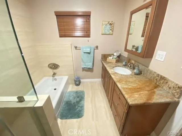 a spacious bathroom with a granite countertop sink a mirror a vanity and bathtub