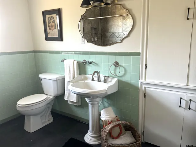 a bathroom with a toilet sink and mirror