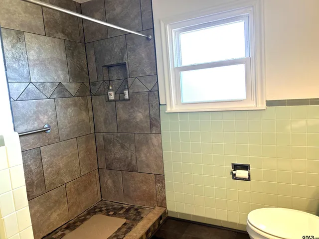 a bathroom with a toilet and a shower