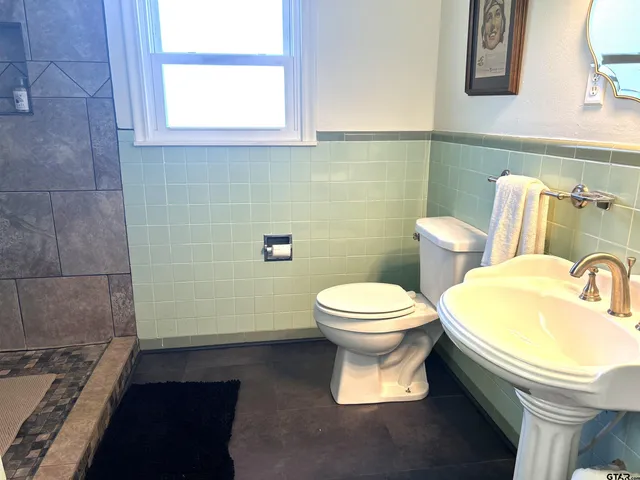 a bathroom with a toilet sink and mirror