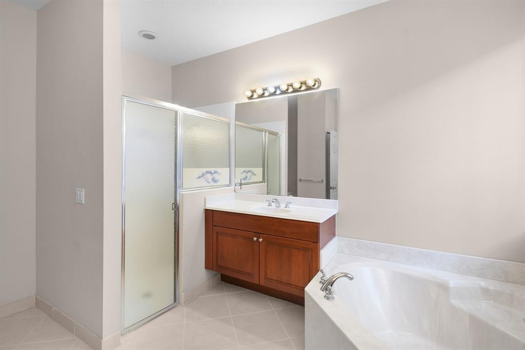 7084 Southeast Cricket Court Stuart, FL 34997 - Photo 18 of 51 a bathroom with a bathtub sink and mirror