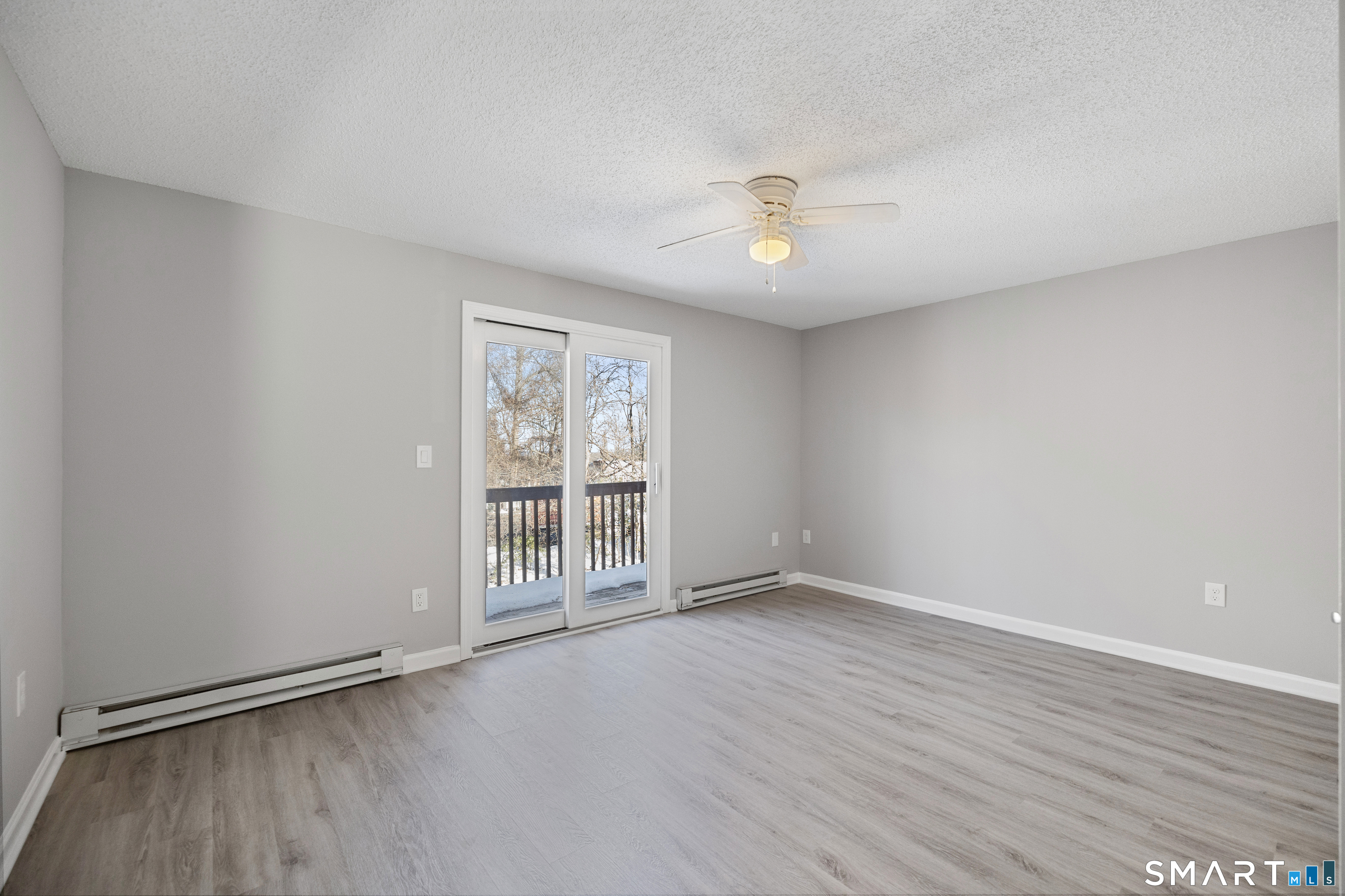 181 Sherbrook Street, Unit A3 Bristol, CT 06010 - Photo 11 of 18 an empty room with wooden floor and windows