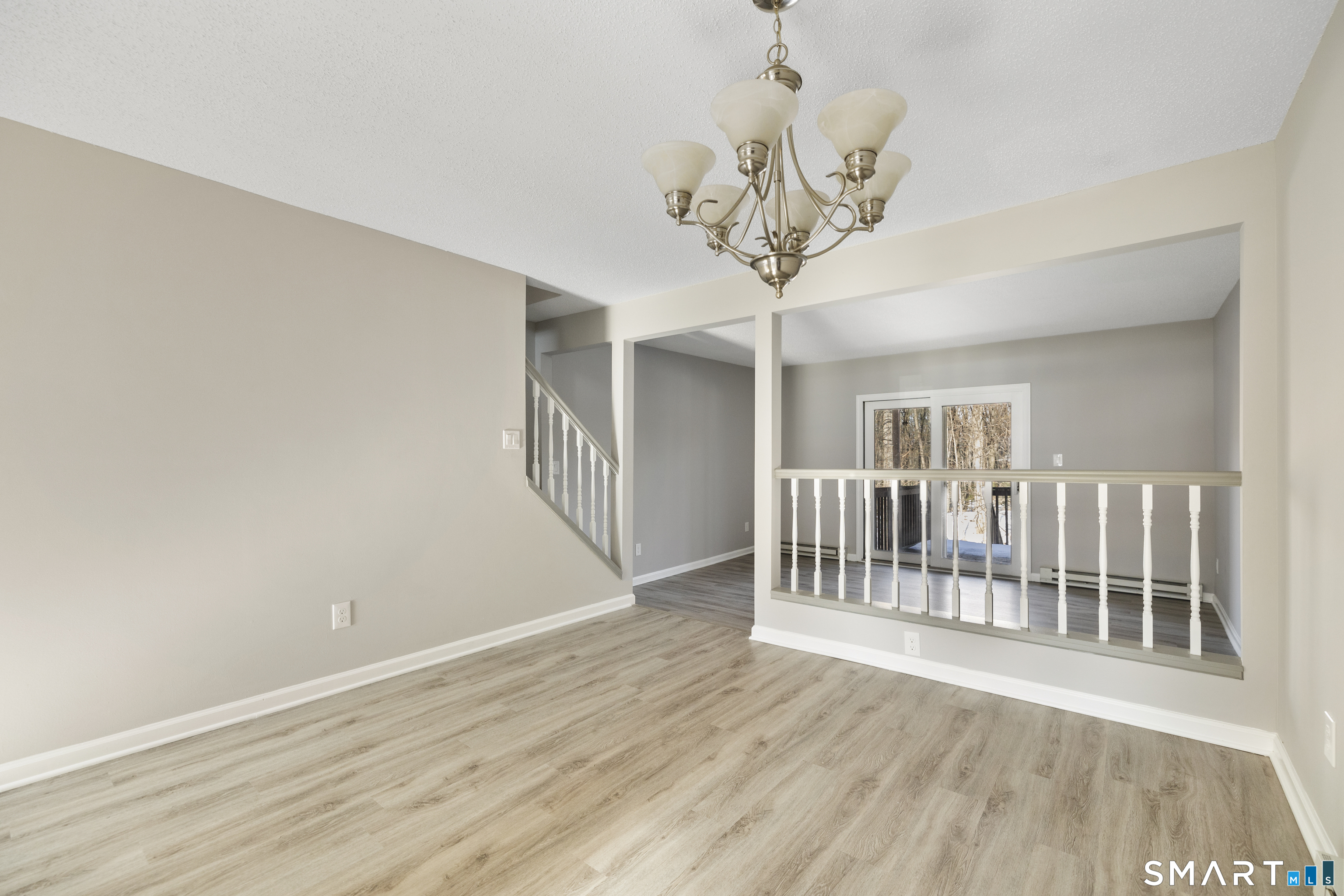 181 Sherbrook Street, Unit A3 Bristol, CT 06010 - Photo 6 of 18 a view of a livingroom with wooden floor and chandelier