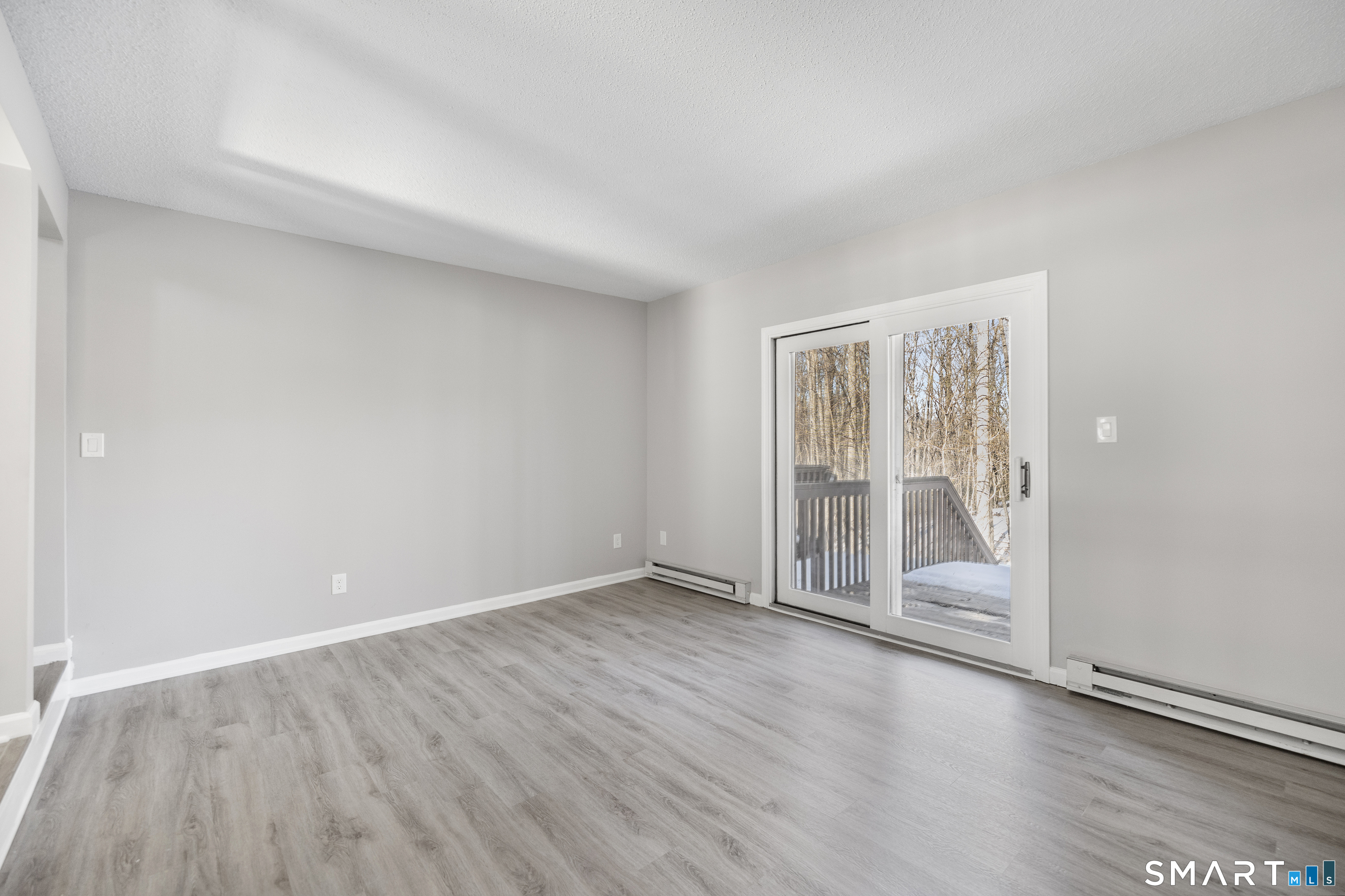 181 Sherbrook Street, Unit A3 Bristol, CT 06010 - Photo 7 of 18 an empty room with wooden floor and windows