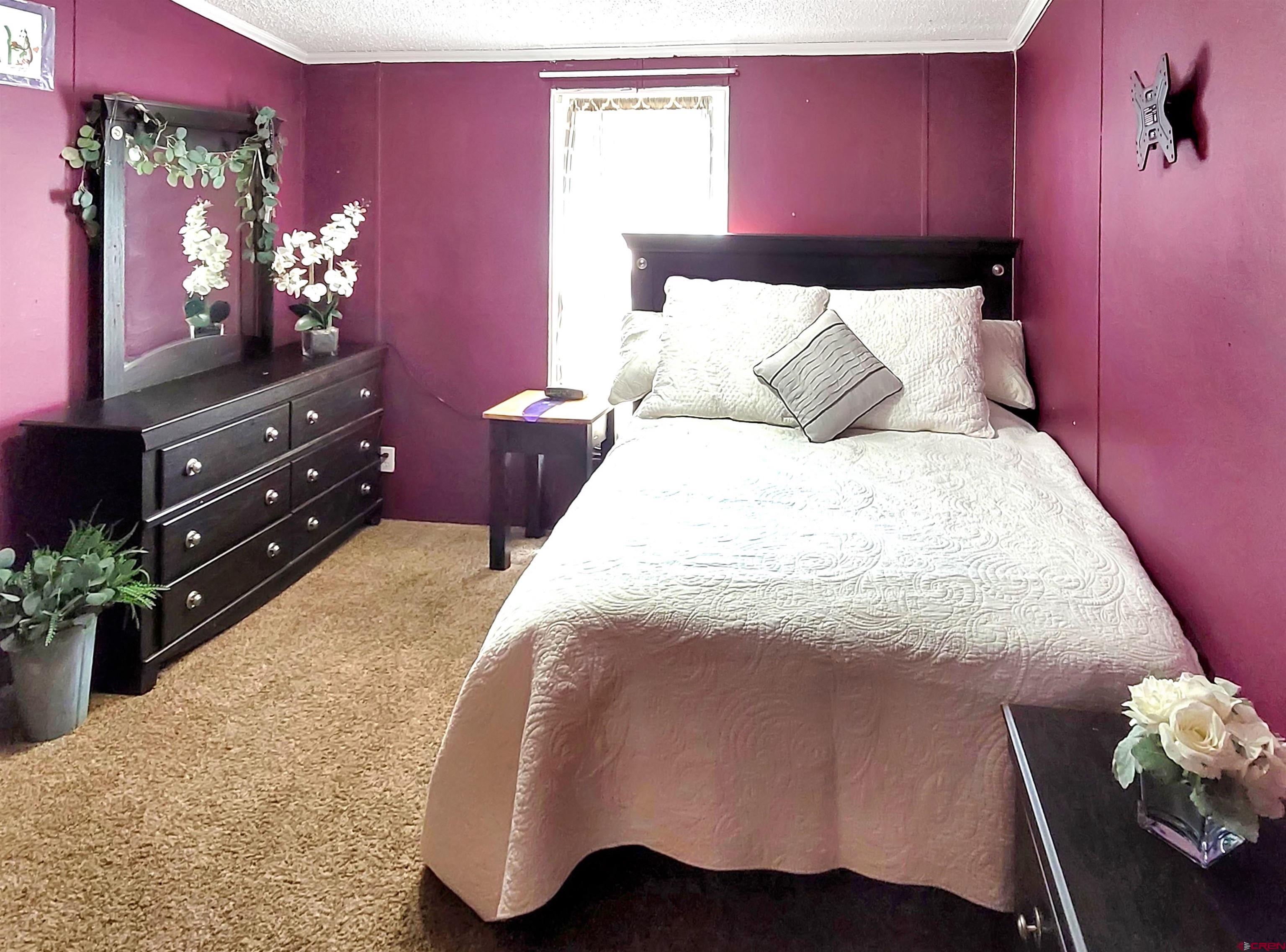 62302 David Road Olathe, CO 81425 - Photo 11 of 15 a bedroom with a bed potted plant on dresser and a chair