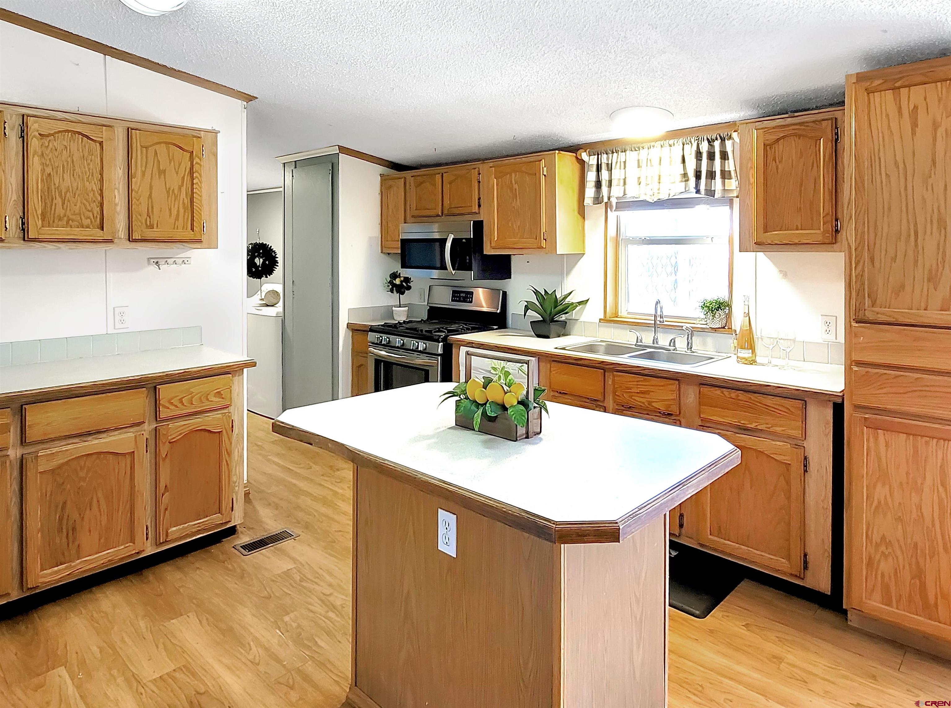 62302 David Road Olathe, CO 81425 - Photo 6 of 15 a kitchen with stainless steel appliances granite countertop a sink a stove and refrigerator