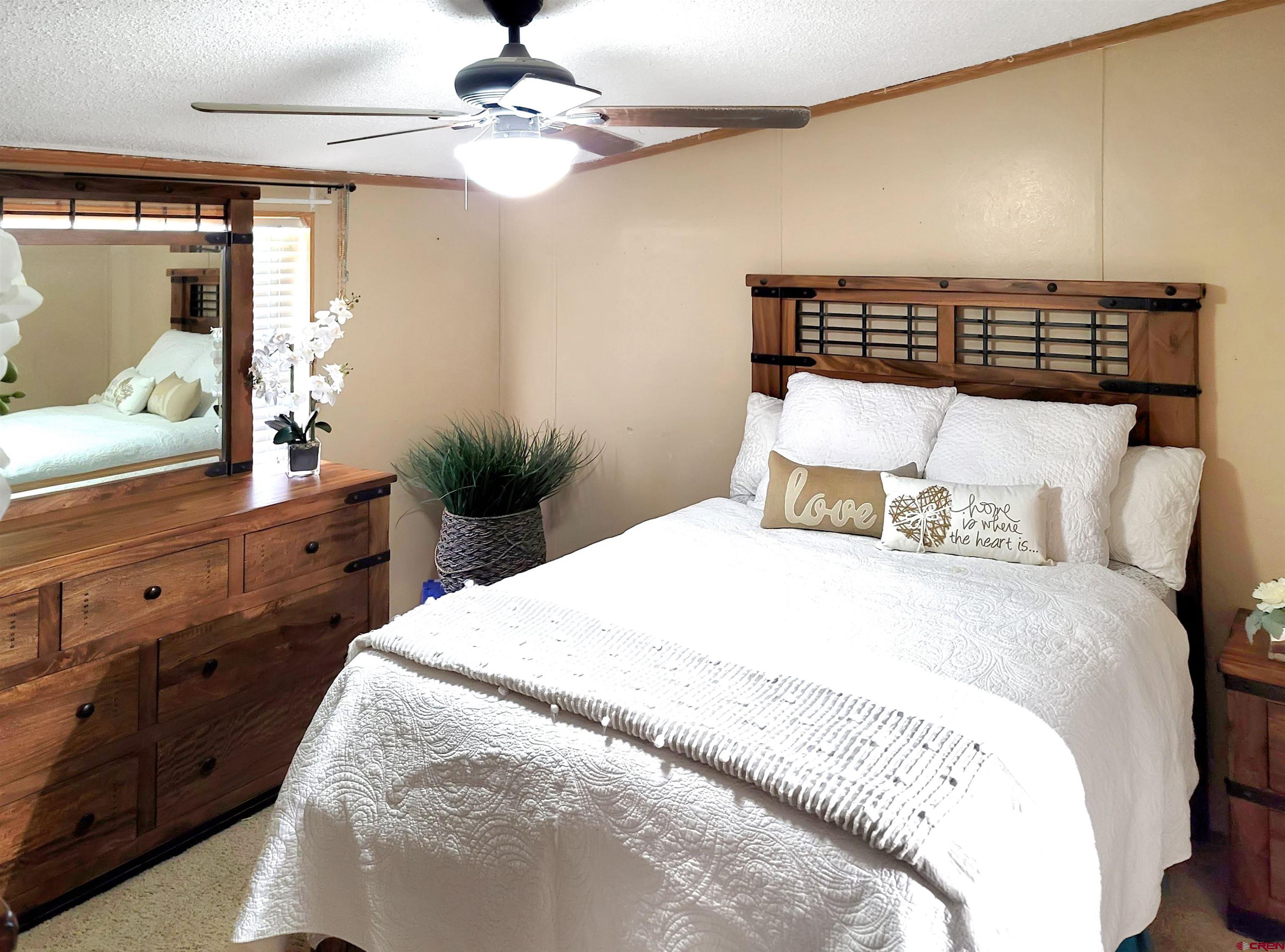 62302 David Road Olathe, CO 81425 - Photo 7 of 15 a bedroom with a large bed and a flat tv screen on dresser