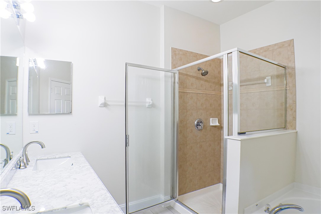 8876 Falcon Pointe Loop Fort Myers, FL 33912 - Photo 13 of 31 a bathroom with a granite countertop sink mirror and shower