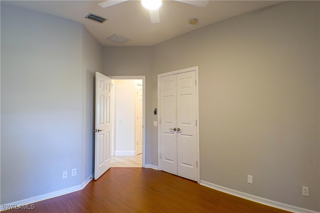 8876 Falcon Pointe Loop Fort Myers, FL 33912 - Photo 19 of 31 an empty room with wooden floor and windows