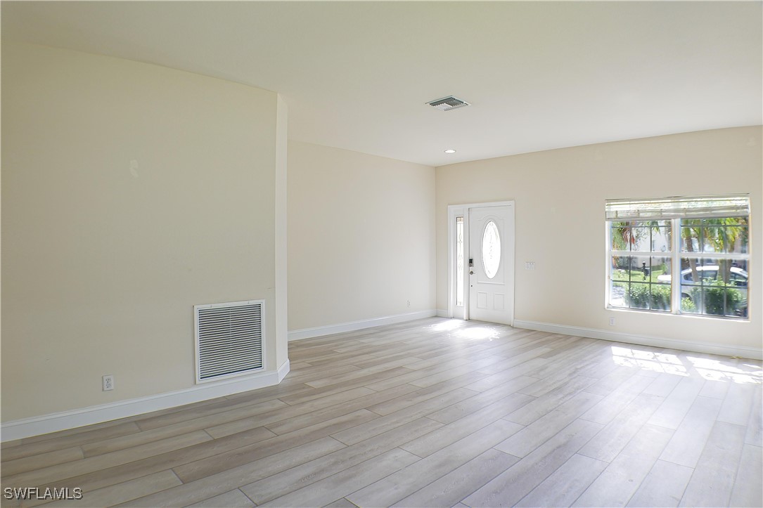 8876 Falcon Pointe Loop Fort Myers, FL 33912 - Photo 5 of 31 a view of an empty room with wooden floor and a window