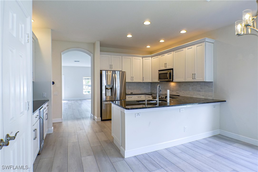 8876 Falcon Pointe Loop Fort Myers, FL 33912 - Photo 8 of 31 a kitchen with stainless steel appliances a refrigerator and a stove top oven