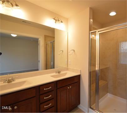 2021 Hayes Lane Holly Springs, NC 27540 - Photo 12 of 25 a bathroom with a double vanity sink mirror and shower