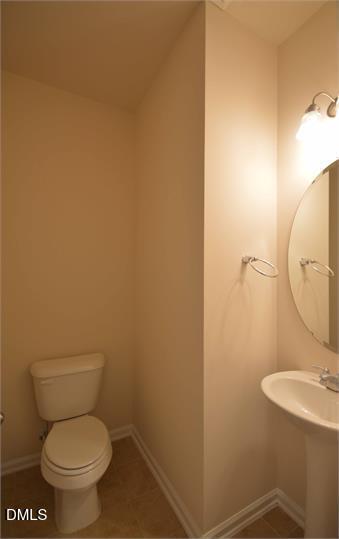 2021 Hayes Lane Holly Springs, NC 27540 - Photo 15 of 25 a white toilet sitting next to a bathroom sink and vanity