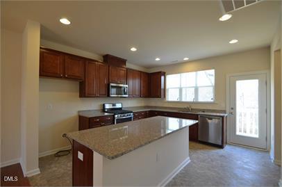 2021 Hayes Lane Holly Springs, NC 27540 - Photo 4 of 25 a kitchen with stainless steel appliances granite countertop a sink stove and cabinets