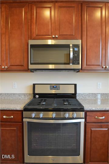 2021 Hayes Lane Holly Springs, NC 27540 - Photo 5 of 25 a kitchen with granite countertop a stove microwave and sink