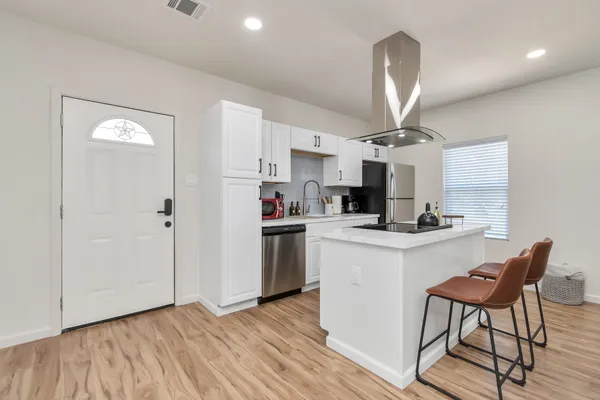a kitchen with white cabinets and white appliances