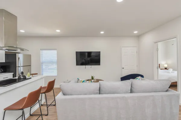 a living room with furniture and a wooden floor