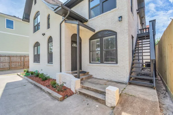 a kitchen with stainless steel appliances granite countertop a stove a sink a refrigerator white cabinets and wooden floor