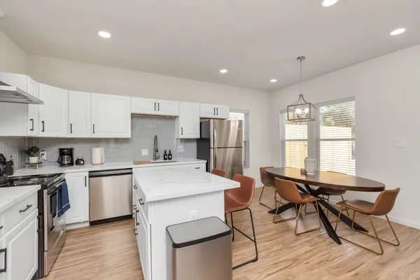 a living room with furniture and a dining table with kitchen view