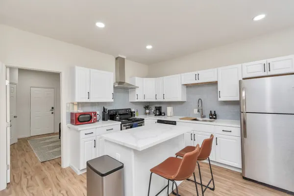 a kitchen with a sink white cabinets and appliances