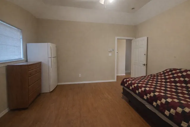 a bedroom with bed and wooden floor